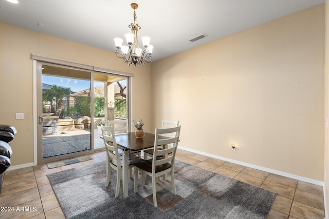 tiled dining room with a notable chandelier