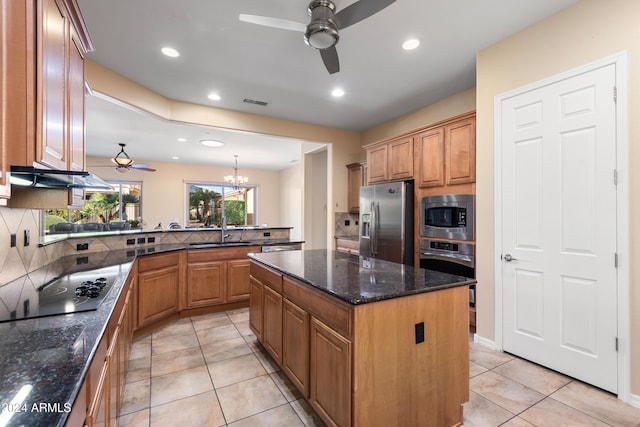 kitchen featuring backsplash, appliances with stainless steel finishes, a kitchen island, a sink, and a peninsula