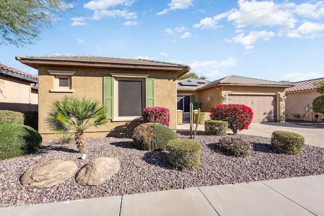 view of front of property featuring solar panels and a garage