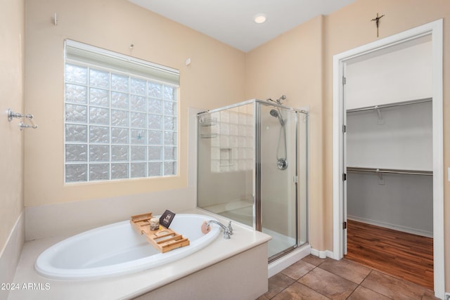 full bath with a garden tub, recessed lighting, tile patterned floors, a stall shower, and a walk in closet