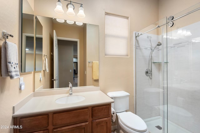 full bathroom with toilet, a shower stall, and vanity