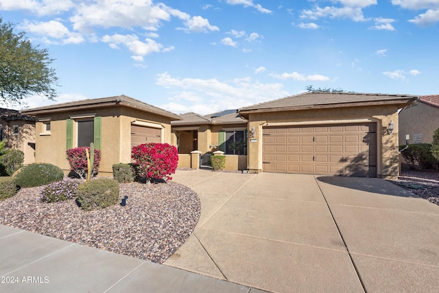 view of front of property featuring concrete driveway, an attached garage, and stucco siding