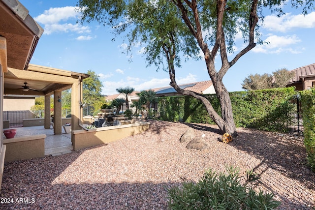 view of yard with a ceiling fan and a patio