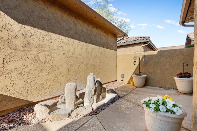 view of property exterior with a tile roof and stucco siding