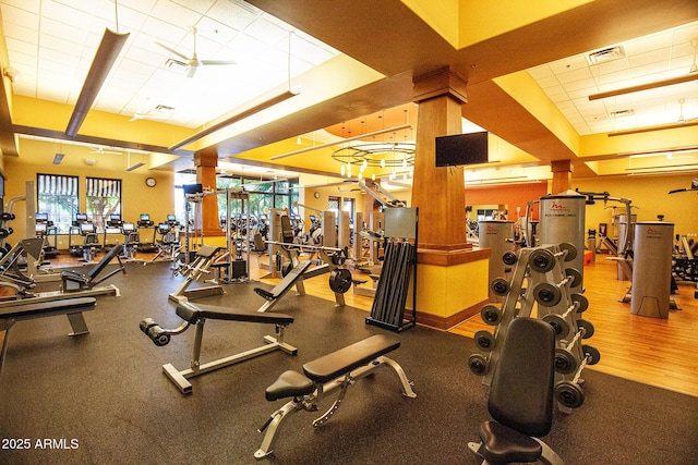 exercise room featuring a paneled ceiling, visible vents, and baseboards