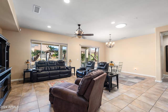 tiled living room with ceiling fan with notable chandelier