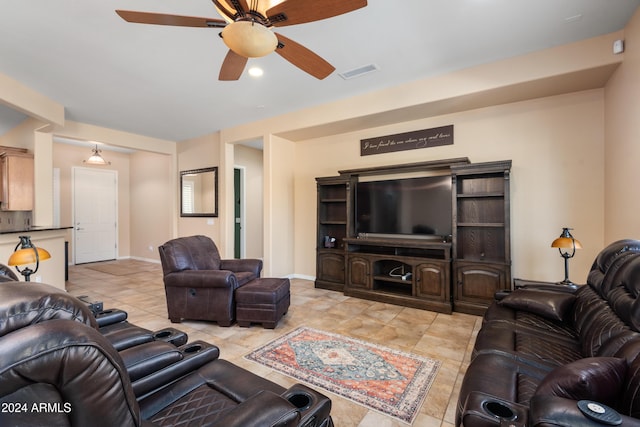 living room with light tile patterned floors, a ceiling fan, visible vents, and baseboards