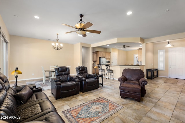 living room featuring recessed lighting, baseboards, and ceiling fan with notable chandelier