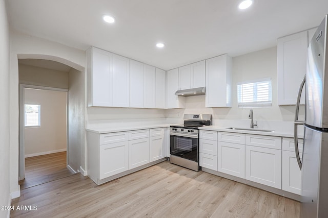 kitchen featuring light wood-type flooring, stainless steel appliances, white cabinetry, and sink