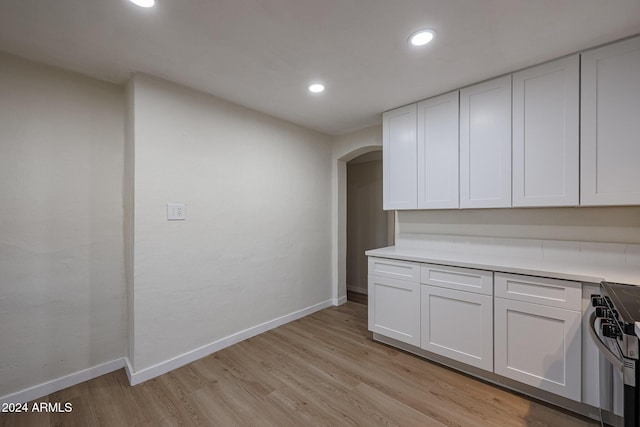 kitchen featuring stove, white cabinets, and light hardwood / wood-style floors