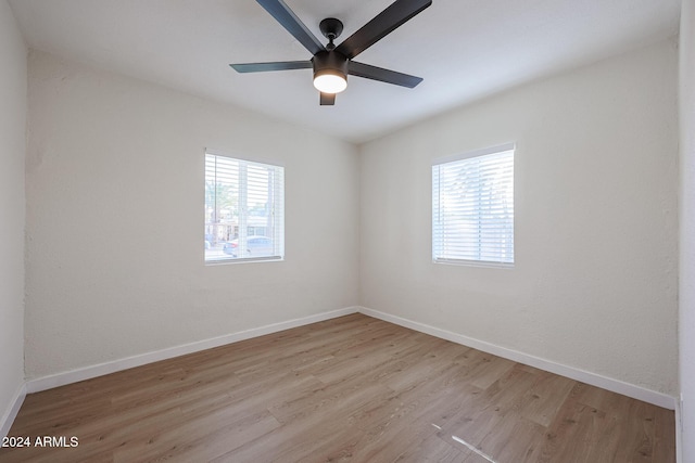 unfurnished room with light hardwood / wood-style floors, a wealth of natural light, and ceiling fan