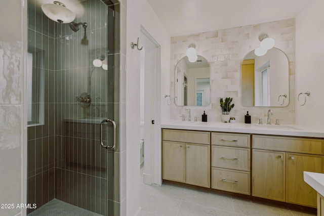 bathroom featuring double vanity, a stall shower, and a sink