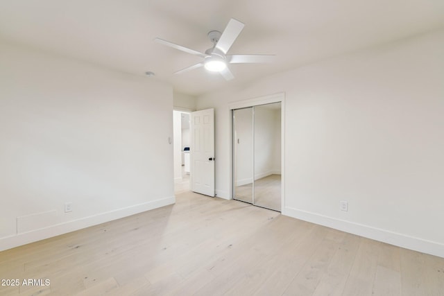 unfurnished bedroom featuring a closet, a ceiling fan, light wood-type flooring, and baseboards