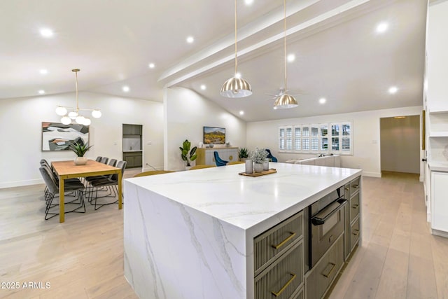 kitchen featuring a large island, lofted ceiling with beams, light wood finished floors, light stone countertops, and hanging light fixtures