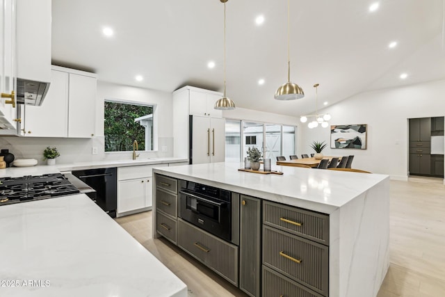 kitchen featuring black appliances, a center island, light wood-type flooring, white cabinetry, and a sink