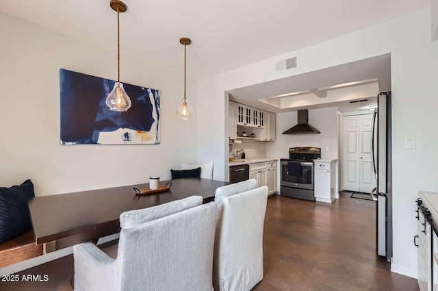 dining area with a tray ceiling, visible vents, and baseboards