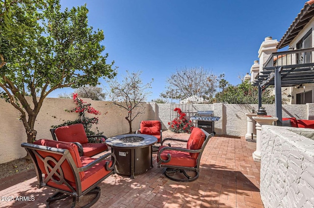 view of patio with an outdoor fire pit, a fenced backyard, area for grilling, and a pergola