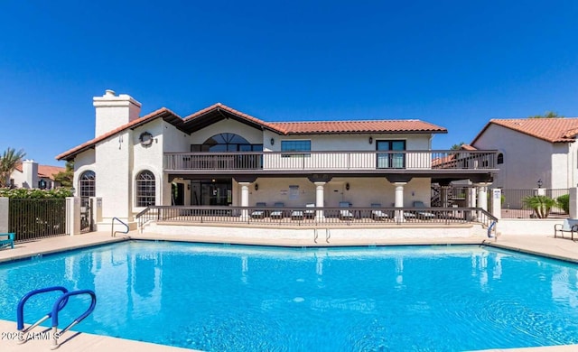 community pool featuring fence and a patio