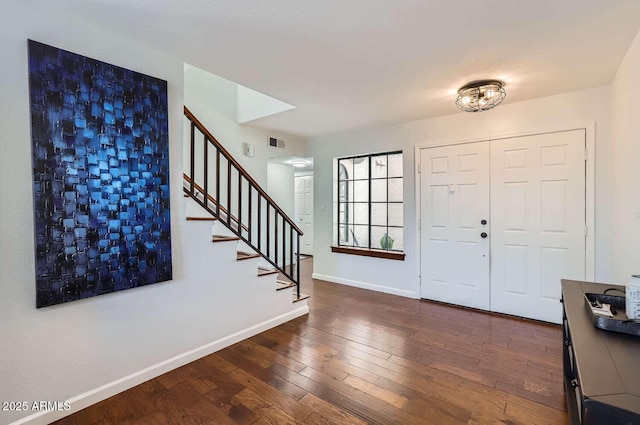 foyer with dark wood-style flooring, visible vents, baseboards, and stairs