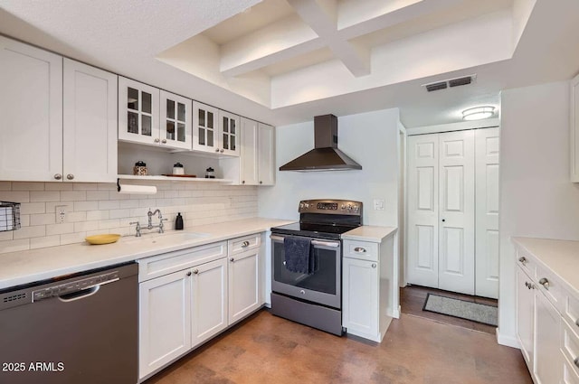 kitchen featuring visible vents, white cabinets, wall chimney exhaust hood, appliances with stainless steel finishes, and a sink