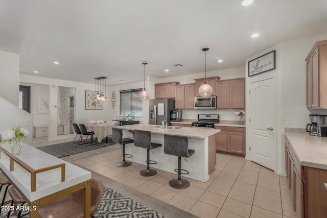 4010 W Coles Rd, Laveen, AZ 85339 - kitchen featuring stainless steel appliances, a sink, a breakfast bar area, light tile patterned flooring, and light countertops