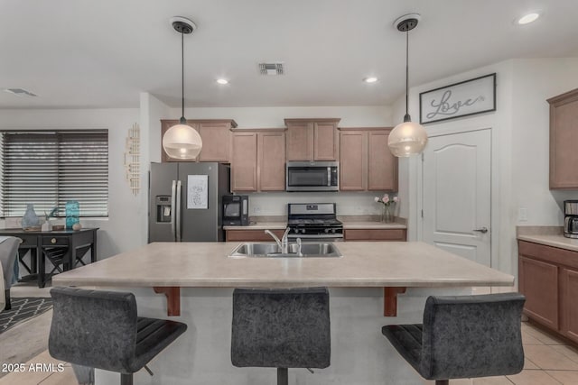 4010 W Coles Rd, Laveen, AZ 85339 - kitchen with appliances with stainless steel finishes, a breakfast bar, light countertops, a sink, and recessed lighting