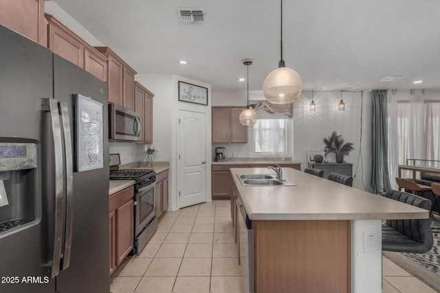 4010 W Coles Rd, Laveen, AZ 85339 - kitchen with appliances with stainless steel finishes, a sink, light tile patterned floors, light countertops, and a center island with sink