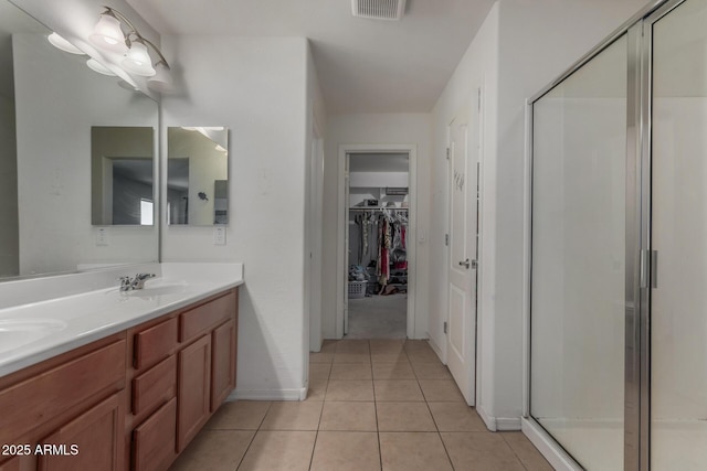 4010 W Coles Rd, Laveen, AZ 85339 - full bathroom featuring double vanity, a shower stall, a spacious closet, tile patterned flooring, and baseboards