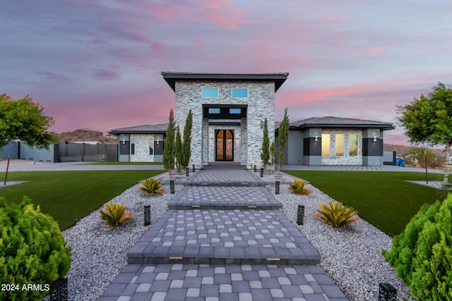 exterior space with stone siding, a front yard, and fence