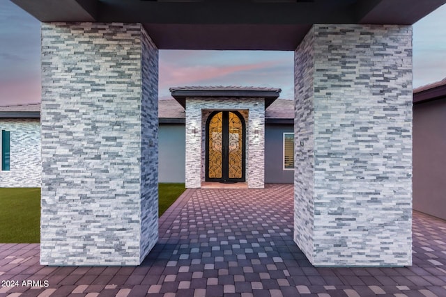 exterior entry at dusk with stone siding