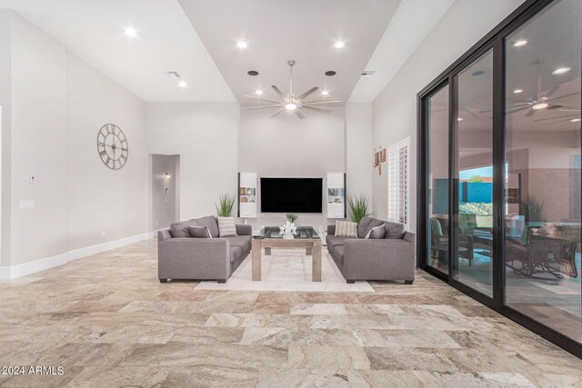 living room with light tile patterned flooring, a high ceiling, and ceiling fan