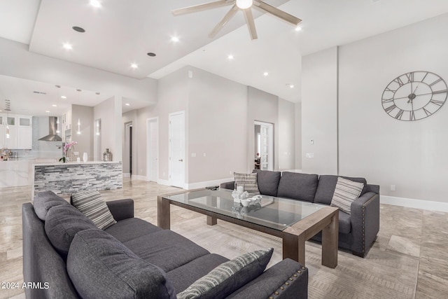 living area featuring recessed lighting, baseboards, a towering ceiling, and a ceiling fan