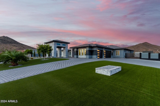 view of front of property featuring a front yard, fence, stucco siding, decorative driveway, and a mountain view