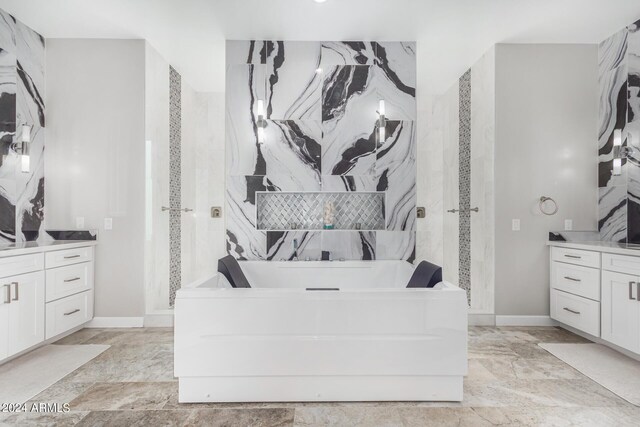 bathroom featuring vanity, a washtub, and tile patterned floors