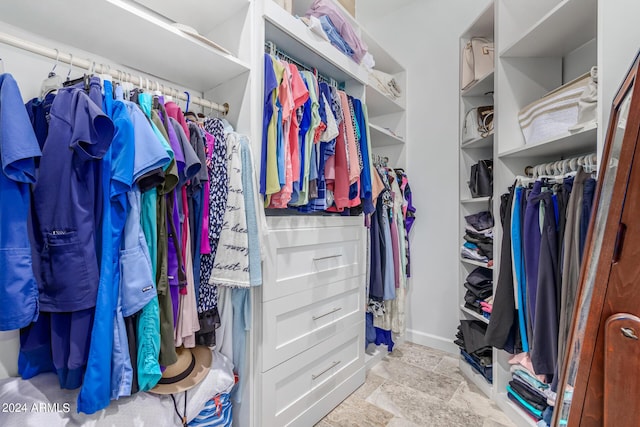 walk in closet with stone finish flooring