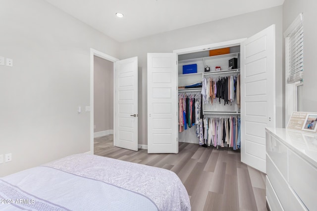 bedroom featuring a closet, recessed lighting, baseboards, and wood finished floors