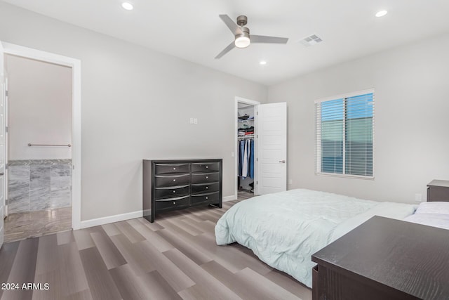 bedroom with visible vents, a walk in closet, wood finished floors, recessed lighting, and baseboards