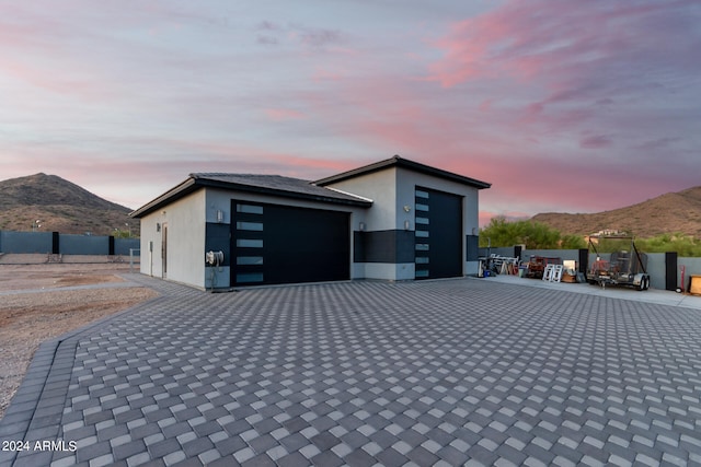 garage at dusk featuring a mountain view