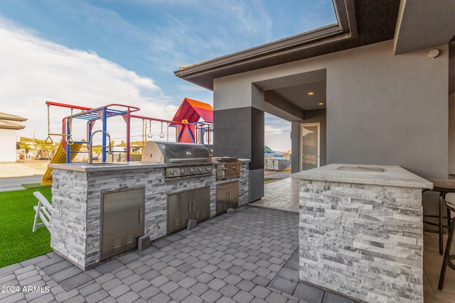 view of patio / terrace featuring area for grilling and a playground