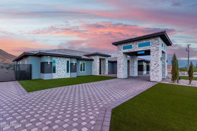 back house at dusk with a lawn