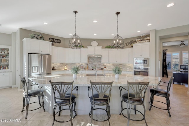 kitchen with stainless steel appliances, white cabinets, and a spacious island