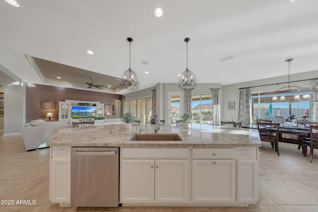 kitchen featuring sink, a center island with sink, dishwasher, light stone countertops, and white cabinets