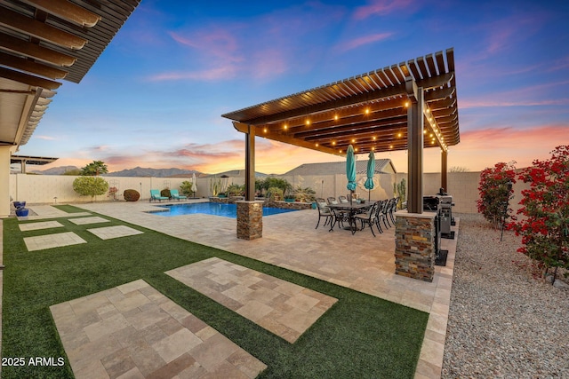 patio terrace at dusk with a fenced in pool, a mountain view, and a grill