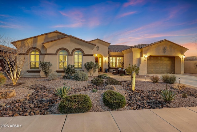 mediterranean / spanish-style home with a garage