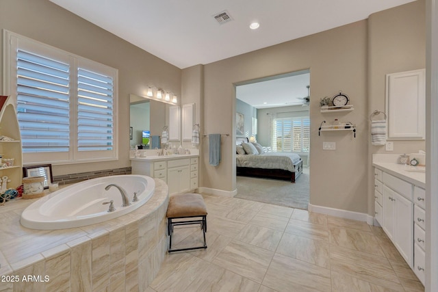 bathroom featuring a relaxing tiled tub, ceiling fan, and vanity