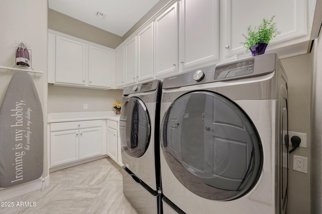 washroom featuring separate washer and dryer and cabinets