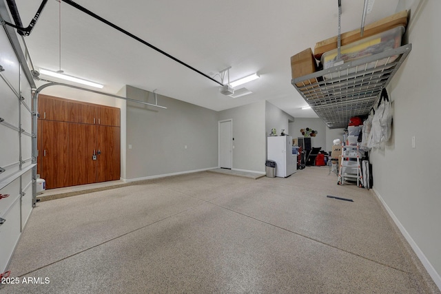 garage featuring white refrigerator and a garage door opener