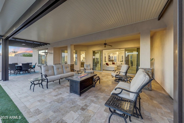 patio terrace at dusk with an outdoor living space with a fire pit