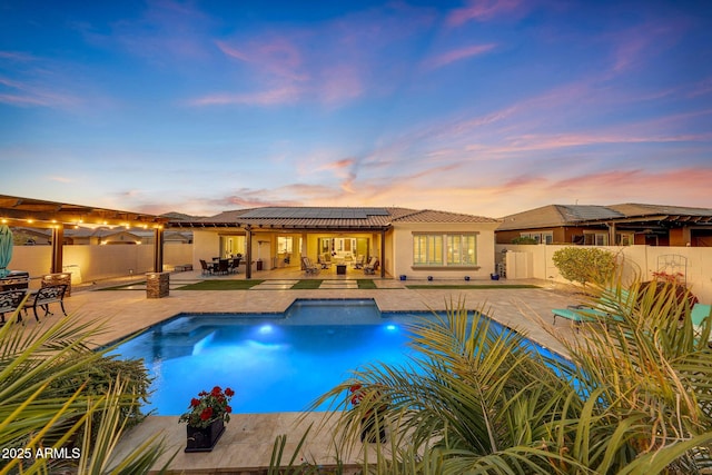 pool at dusk featuring a patio