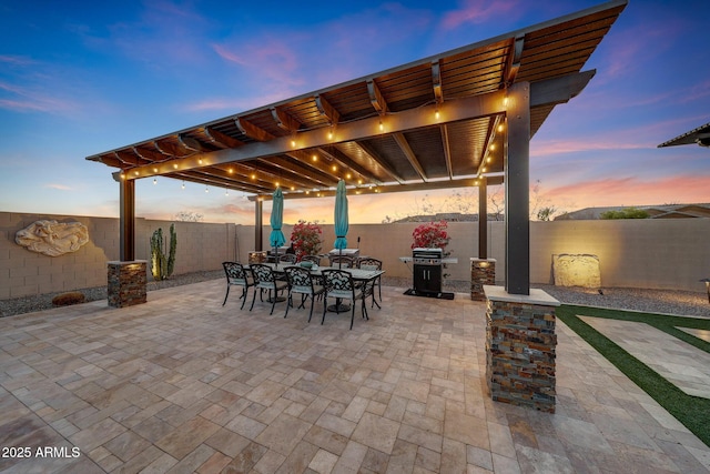 patio terrace at dusk featuring a pergola